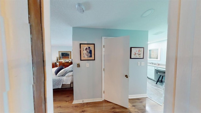 2215 Toniwood Ln, Palm Harbor, FL 34685 - hallway featuring light wood-type flooring and baseboards