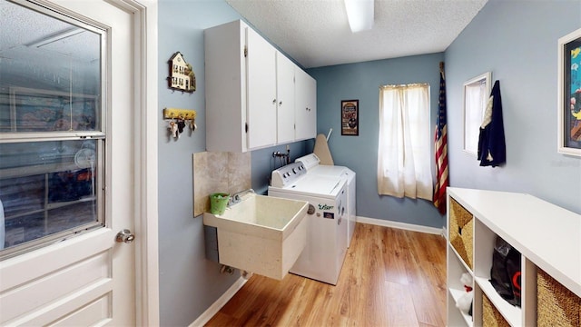 2215 Toniwood Ln, Palm Harbor, FL 34685 - laundry room with cabinet space, washer and dryer, light wood-style floors, and a textured ceiling