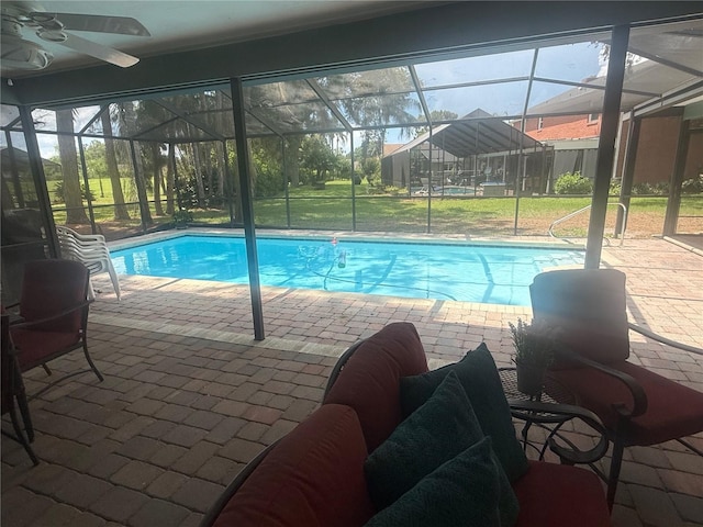 2215 Toniwood Ln, Palm Harbor, FL 34685 - outdoor pool with glass enclosure, a patio area, ceiling fan, and a lawn