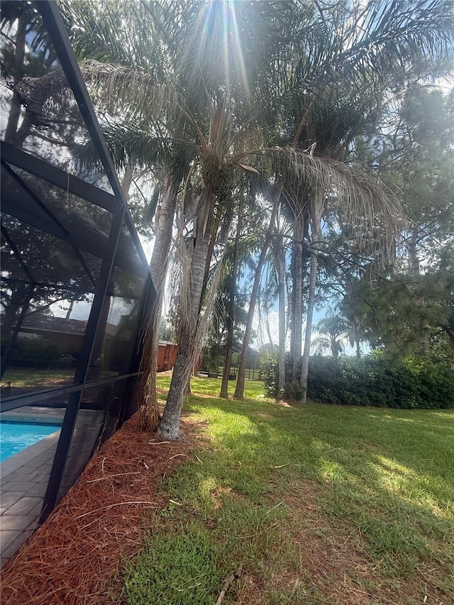 2215 Toniwood Ln, Palm Harbor, FL 34685 - view of green lawn with an outdoor pool and glass enclosure