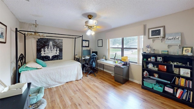 2215 Toniwood Ln, Palm Harbor, FL 34685 - bedroom featuring a chandelier, light wood finished floors, a textured ceiling, a desk, and ceiling fan