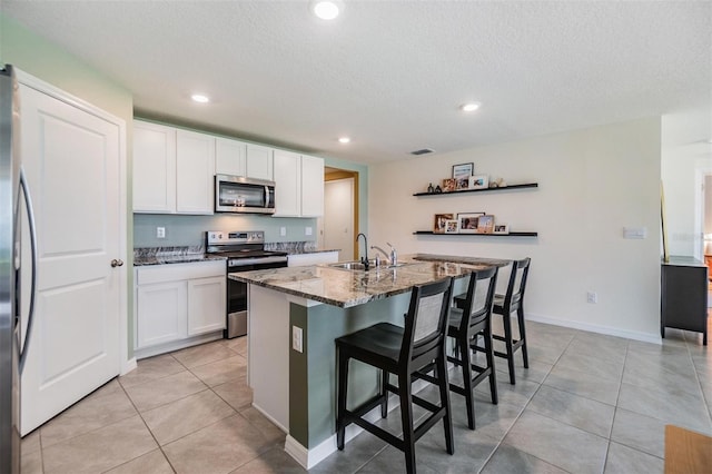 13304 Mylion Way, Spring Hill, FL 34610 - kitchen featuring stainless steel appliances, stone counters, white cabinetry, a breakfast bar, and light tile patterned floors
