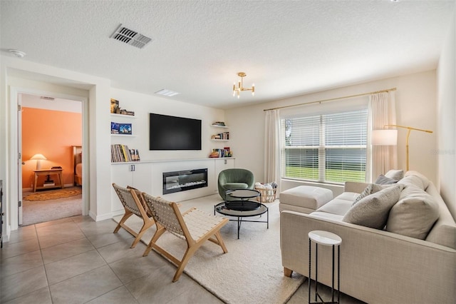 13304 Mylion Way, Spring Hill, FL 34610 - living area with a chandelier, a textured ceiling, a glass covered fireplace, and light tile patterned floors