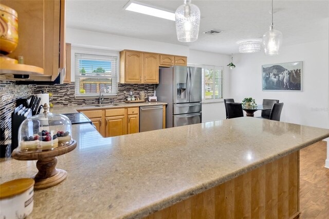 10811 Providence Oaks Dr, Riverview, FL 33578 - kitchen with stainless steel appliances, tasteful backsplash, pendant lighting, and a peninsula
