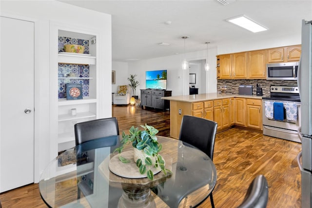 10811 Providence Oaks Dr, Riverview, FL 33578 - kitchen featuring appliances with stainless steel finishes, a peninsula, dark wood-style floors, and decorative backsplash