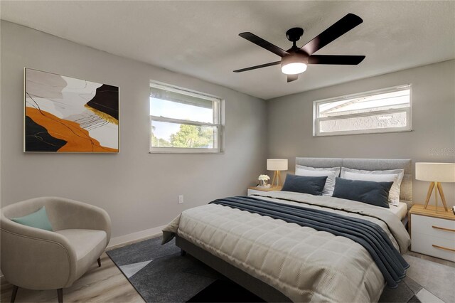 7031 Magnolia Valley Dr, New Port Richey, FL 34653 - bedroom with multiple windows, wood finished floors, and a ceiling fan