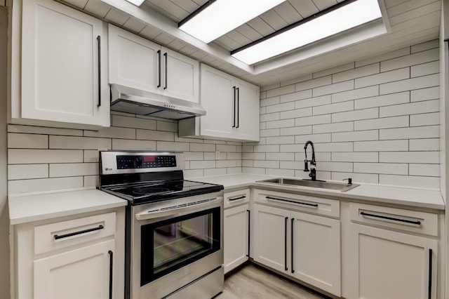 7031 Magnolia Valley Dr, New Port Richey, FL 34653 - kitchen featuring stainless steel electric stove, under cabinet range hood, decorative backsplash, and white cabinetry
