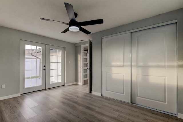 7031 Magnolia Valley Dr, New Port Richey, FL 34653 - unfurnished bedroom featuring french doors, access to outside, wood finished floors, a closet, and a ceiling fan