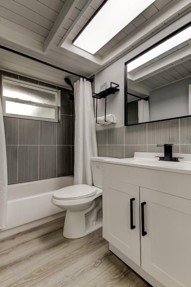7031 Magnolia Valley Dr, New Port Richey, FL 34653 - full bathroom with vanity, shower / bathtub combination with curtain, wood finished floors, and tile walls