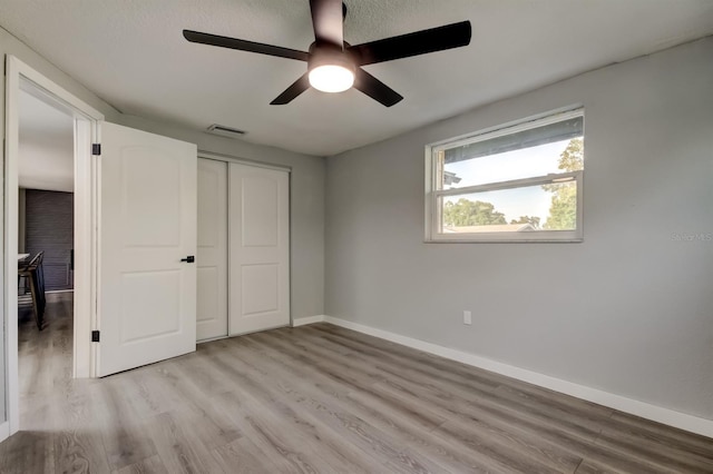7031 Magnolia Valley Dr, New Port Richey, FL 34653 - unfurnished bedroom with light wood-type flooring, a closet, and a ceiling fan