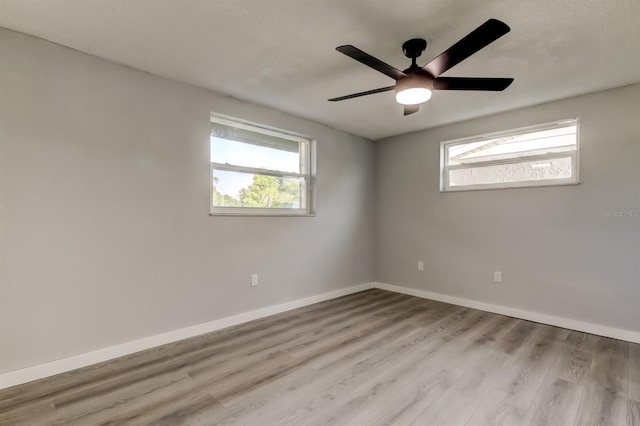 7031 Magnolia Valley Dr, New Port Richey, FL 34653 - unfurnished room featuring plenty of natural light, wood finished floors, and a ceiling fan