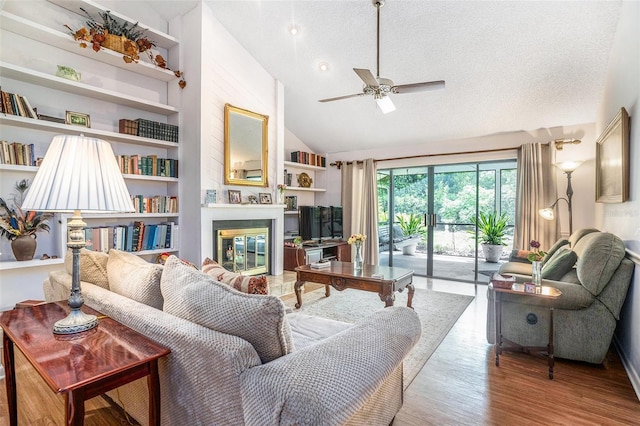3335 Foxridge Cir, Tampa, FL 33618 - living area featuring ceiling fan, a glass covered fireplace, wood finished floors, a textured ceiling, and high vaulted ceiling