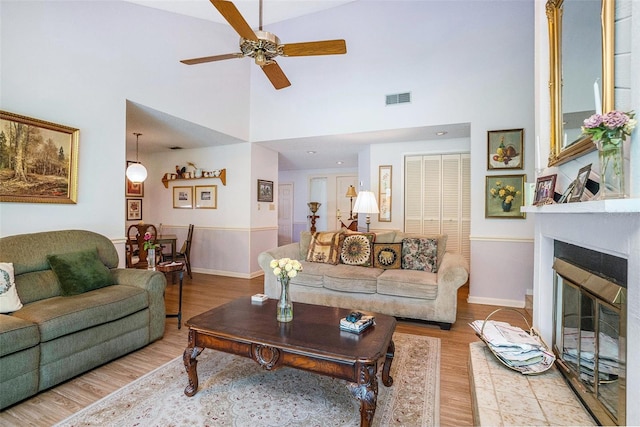 3335 Foxridge Cir, Tampa, FL 33618 - living room with a towering ceiling, wood finished floors, a ceiling fan, and a glass covered fireplace