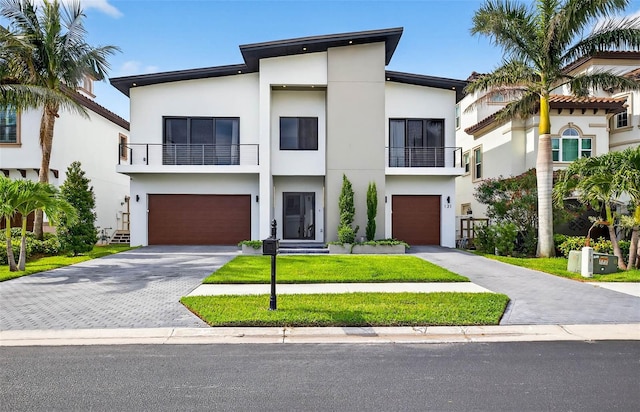 131 Forest Hills Dr, Redington Shores, FL 33708 - view of front of home with a balcony, stucco siding, driveway, and an attached garage