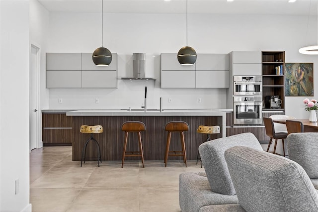 131 Forest Hills Dr, Redington Shores, FL 33708 - kitchen with wall chimney range hood, modern cabinets, double oven, and a kitchen breakfast bar