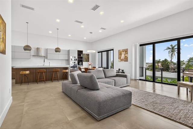 131 Forest Hills Dr, Redington Shores, FL 33708 - living area with a high ceiling, finished concrete flooring, and recessed lighting