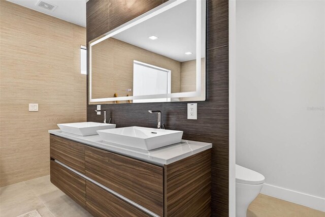 131 Forest Hills Dr, Redington Shores, FL 33708 - full bathroom with tile patterned flooring, double vanity, and tile walls