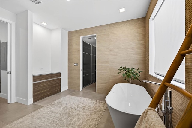 131 Forest Hills Dr, Redington Shores, FL 33708 - full bathroom with a soaking tub, concrete floors, and tile walls