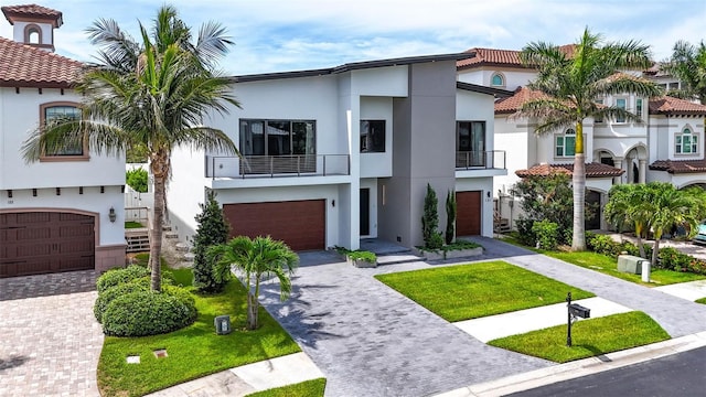 131 Forest Hills Dr, Redington Shores, FL 33708 - view of front of house with stucco siding, decorative driveway, an attached garage, and a balcony
