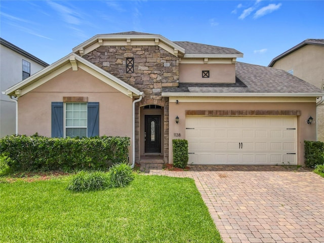 1138 Fountain Coin Loop, Orlando, FL 32828 - view of front of property featuring stucco siding, decorative driveway, a front lawn, and stone siding