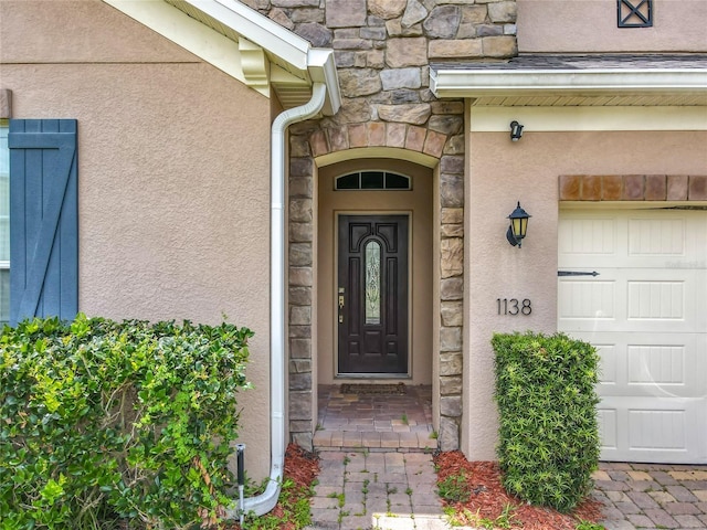 1138 Fountain Coin Loop, Orlando, FL 32828 - property entrance with stucco siding, a garage, and stone siding