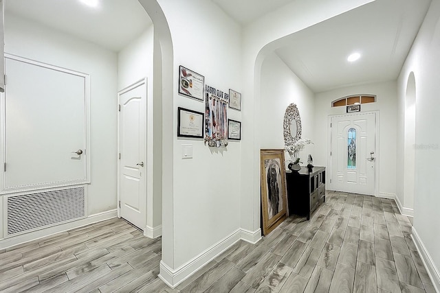 1138 Fountain Coin Loop, Orlando, FL 32828 - foyer entrance with wood tiled floors, arched walkways, and recessed lighting