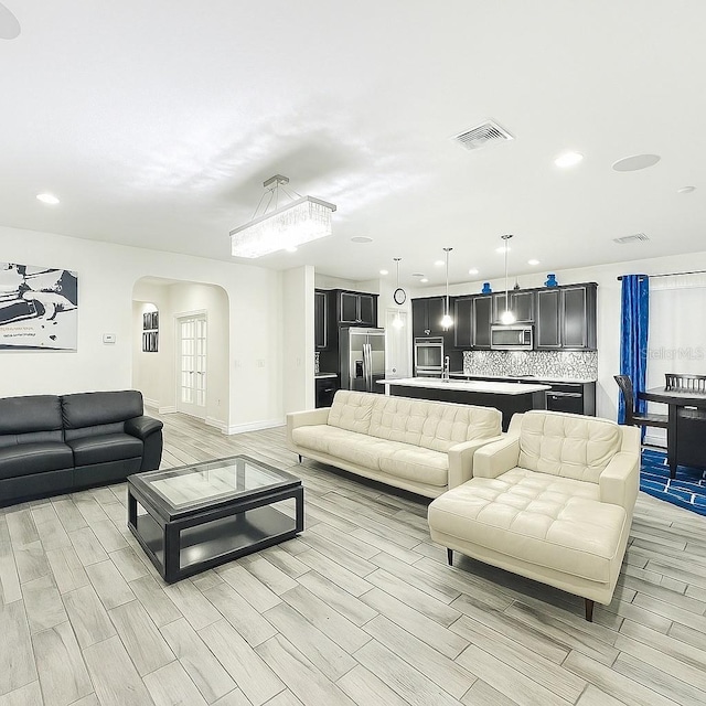 1138 Fountain Coin Loop, Orlando, FL 32828 - living room with arched walkways, wood tiled floors, and recessed lighting