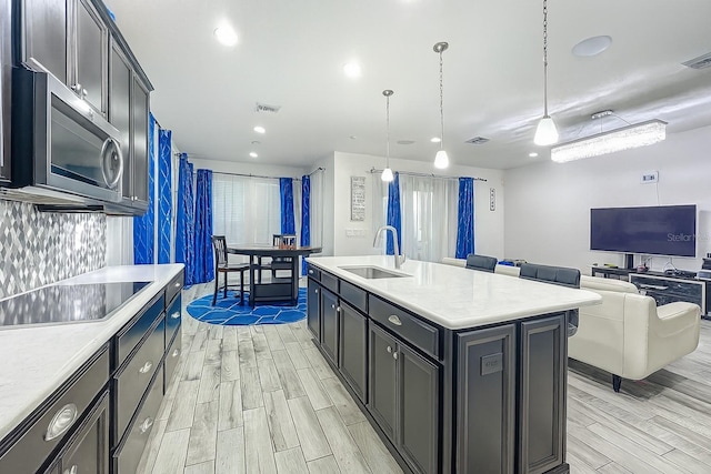 1138 Fountain Coin Loop, Orlando, FL 32828 - kitchen featuring stainless steel microwave, wood tiled floors, light countertops, black electric stovetop, and recessed lighting