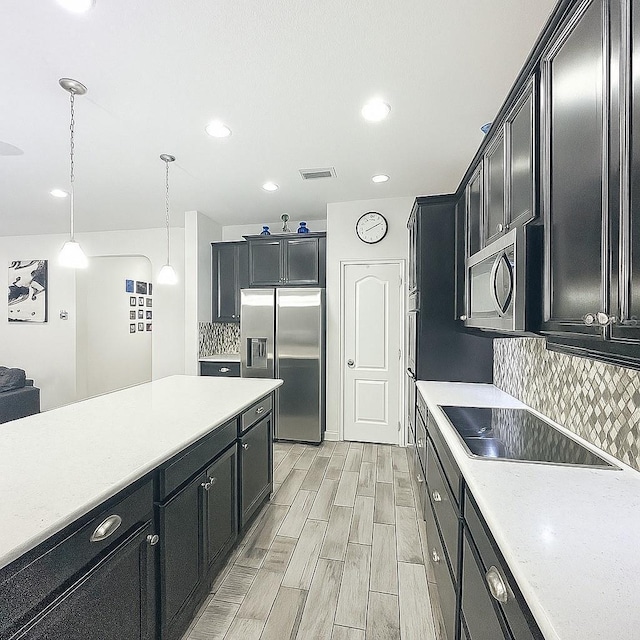 1138 Fountain Coin Loop, Orlando, FL 32828 - kitchen with appliances with stainless steel finishes, dark cabinetry, decorative backsplash, light countertops, and recessed lighting