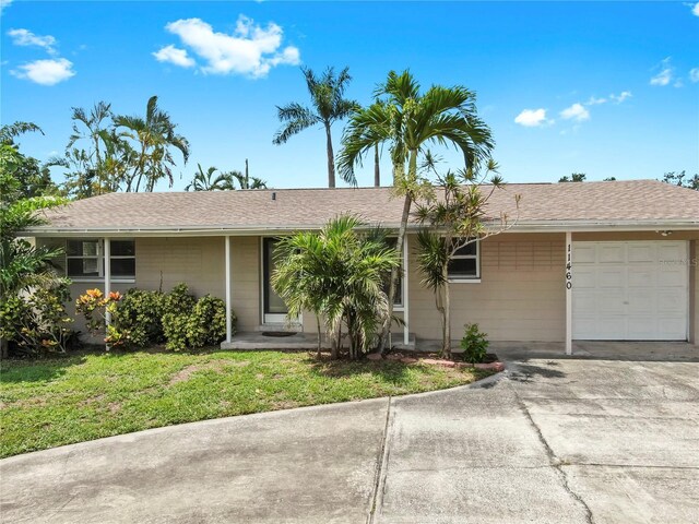 11460 Park Blvd, Seminole, FL 33772 - ranch-style house with a garage, driveway, a front lawn, and a shingled roof
