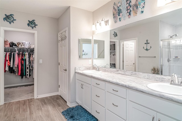 1518 Louise Ave, Auburndale, FL 33823 - bathroom featuring double vanity, a shower stall, a walk in closet, and wood finished floors