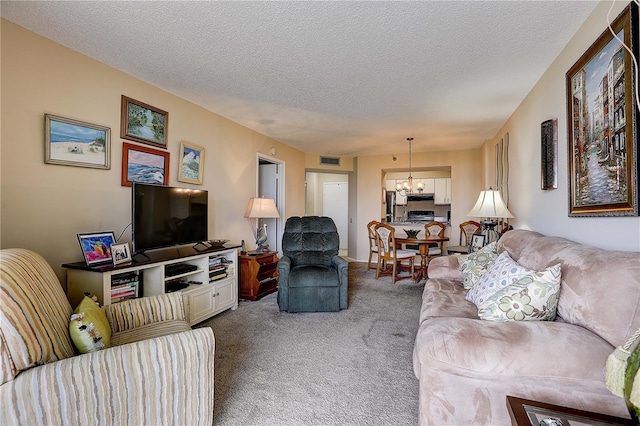 2333 Feather Sound Dr Unit A409, Clearwater, FL 33762 - carpeted living room featuring a chandelier and a textured ceiling