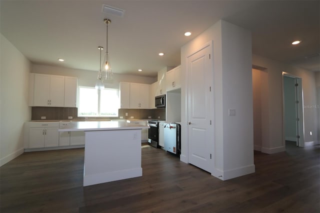 719 Allora Ave, Nokomis, FL 34275 - kitchen with appliances with stainless steel finishes, a kitchen island, white cabinetry, dark wood finished floors, and recessed lighting
