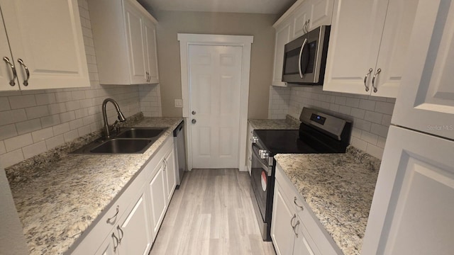 1514 Crest Ave, Leesburg, FL 34748 - kitchen with appliances with stainless steel finishes, white cabinets, light wood-style flooring, and backsplash