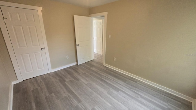 1514 Crest Ave, Leesburg, FL 34748 - unfurnished bedroom with baseboards and wood finished floors