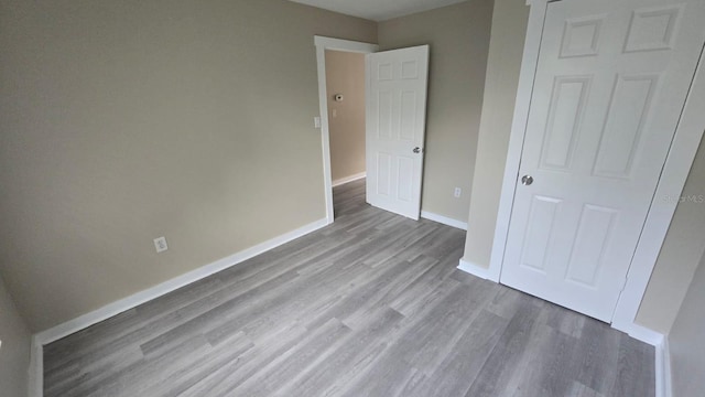 1514 Crest Ave, Leesburg, FL 34748 - unfurnished bedroom with wood finished floors and baseboards