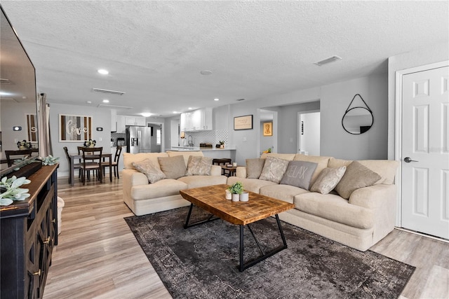 4460 67th St N, Saint Petersburg, FL 33709 - living room with light wood-style flooring, a textured ceiling, and recessed lighting