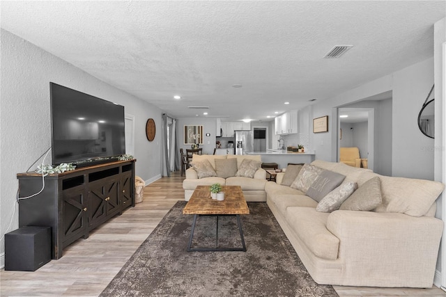 4460 67th St N, Saint Petersburg, FL 33709 - living area featuring light wood finished floors, a textured ceiling, and recessed lighting