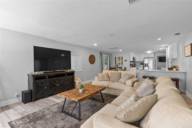 4460 67th St N, Saint Petersburg, FL 33709 - living area with light wood-style floors, a textured ceiling, and recessed lighting