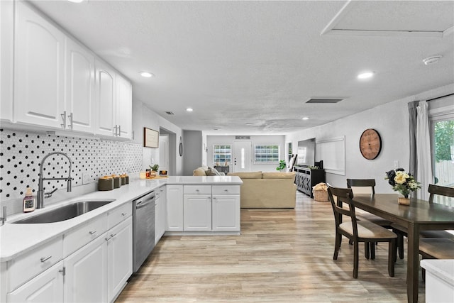 4460 67th St N, Saint Petersburg, FL 33709 - kitchen featuring stainless steel dishwasher, a textured ceiling, light wood-type flooring, open floor plan, and a peninsula