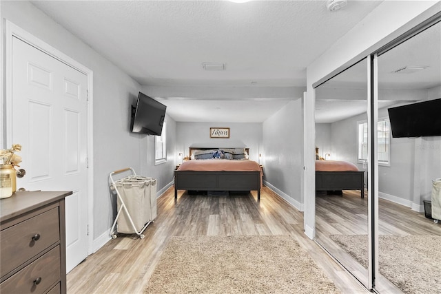 4460 67th St N, Saint Petersburg, FL 33709 - bedroom with light wood-style floors, a closet, and a textured ceiling