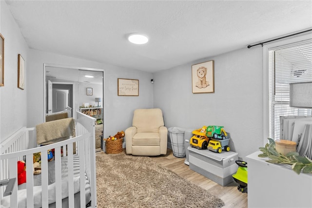 4460 67th St N, Saint Petersburg, FL 33709 - bedroom with a nursery area, wood finished floors, and a textured ceiling