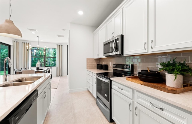 5719 Silverside Pine Ct, Lakewood Ranch, FL 34211 - kitchen featuring appliances with stainless steel finishes, decorative backsplash, white cabinetry, light stone counters, and light tile patterned floors