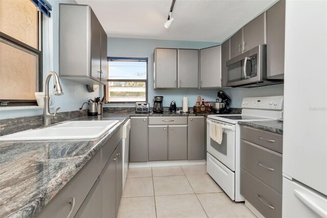 7893 Sailboat Key Blvd S Unit 304, South Pasadena, FL 33707 - kitchen featuring stainless steel microwave, white electric stove, gray cabinetry, and rail lighting