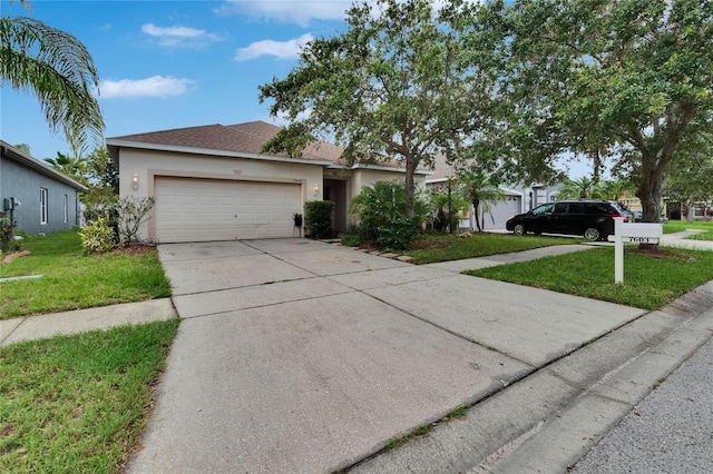 7603 Wood Violet Dr, Gibsonton, FL 33534 - ranch-style home with stucco siding, an attached garage, driveway, and a front yard