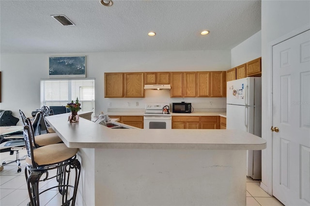 7603 Wood Violet Dr, Gibsonton, FL 33534 - kitchen featuring white appliances, light tile patterned floors, light countertops, under cabinet range hood, and a textured ceiling