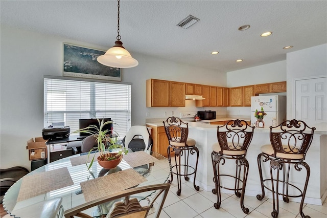 7603 Wood Violet Dr, Gibsonton, FL 33534 - kitchen with white appliances, under cabinet range hood, light countertops, recessed lighting, and a kitchen bar