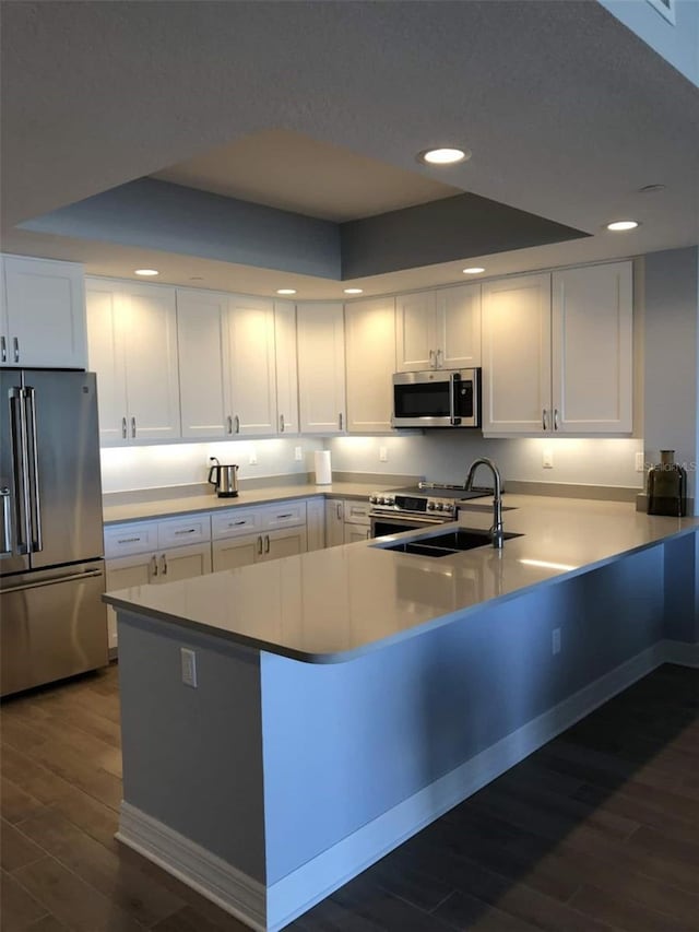 706 Bayway Blvd Unit 502, Clearwater Beach, FL 33767 - kitchen featuring stainless steel appliances, recessed lighting, dark wood-type flooring, white cabinetry, and a peninsula