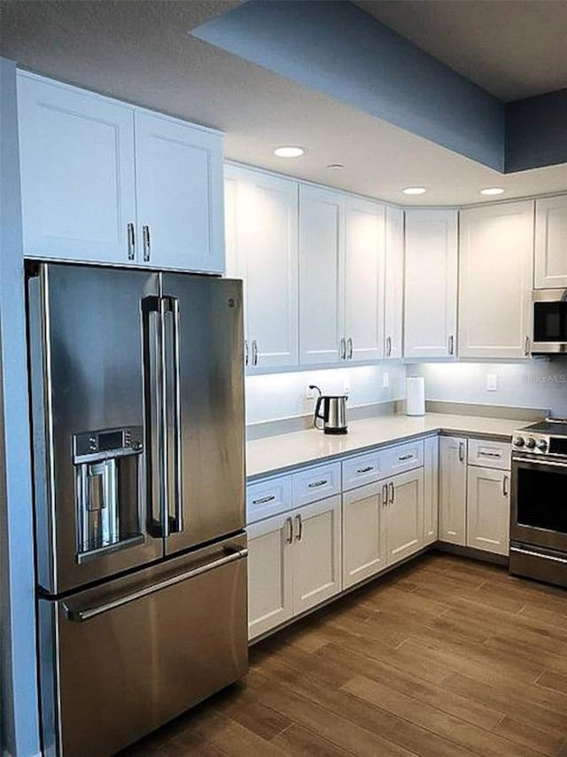 706 Bayway Blvd Unit 502, Clearwater Beach, FL 33767 - kitchen with stainless steel appliances, dark wood-style flooring, light countertops, white cabinetry, and recessed lighting