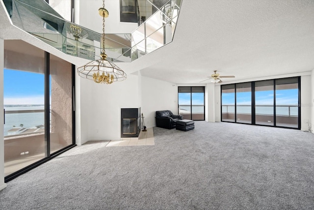 1340 Gulf Blvd Unit 12A, Clearwater Beach, FL 33767 - carpeted living area featuring healthy amount of natural light, a chandelier, ceiling fan, a textured ceiling, and a water view